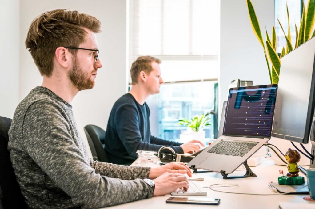 two men working at modern office desk.